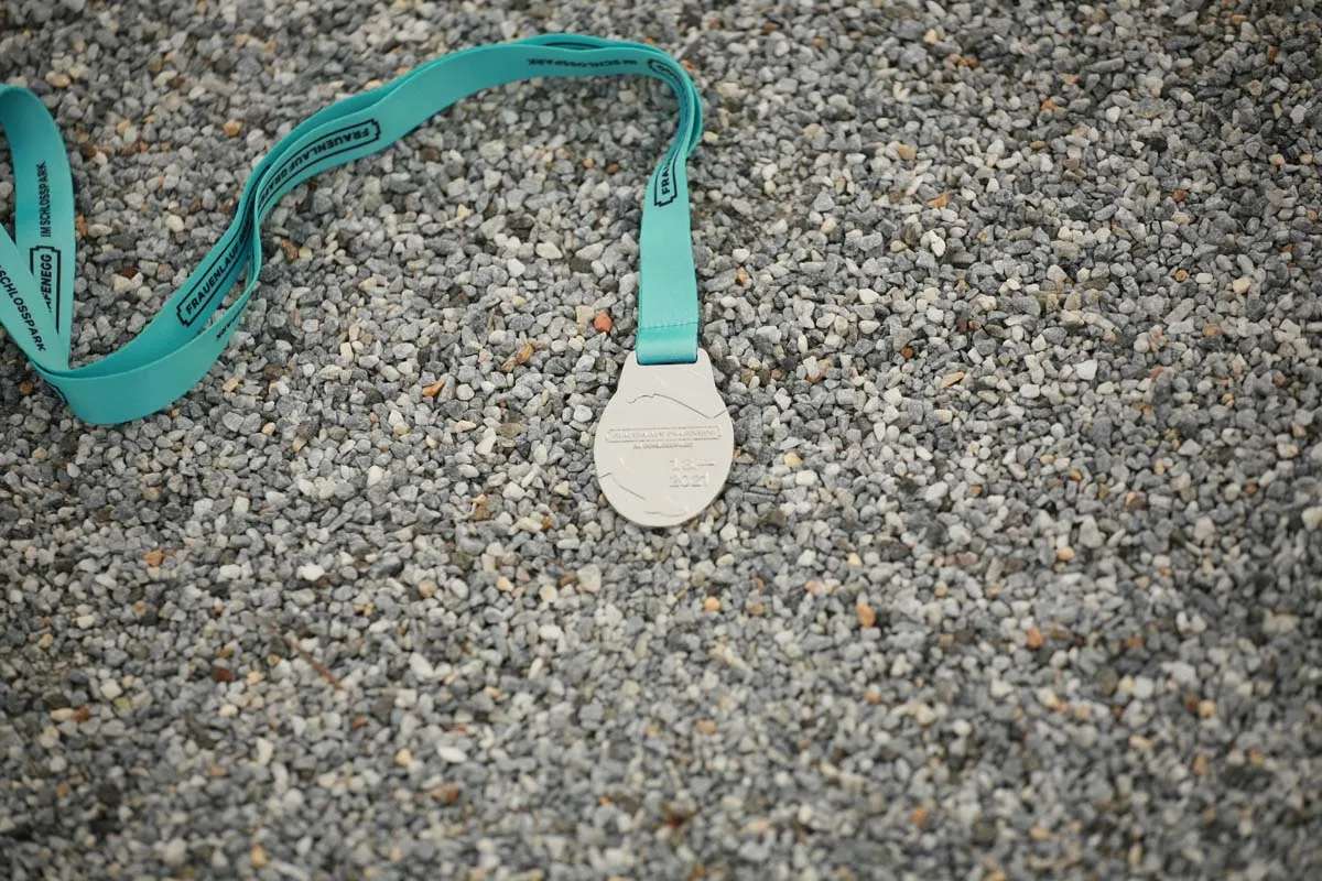 Finisher-Medaille des Frauenlauf Grafenegg mit türkisem Band