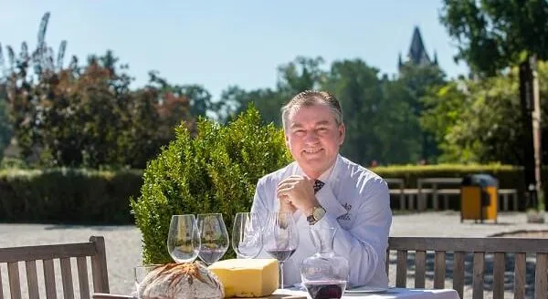Toni Mörwald an einem gedeckten Tisch im Schlosspark